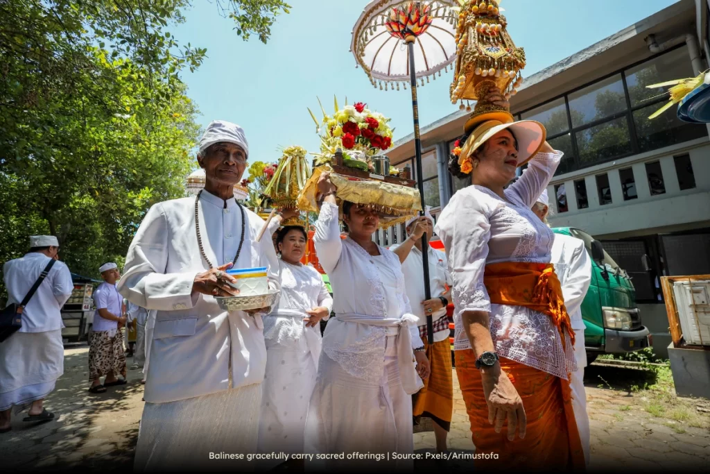 Balinese gracefully carry sacred offerings